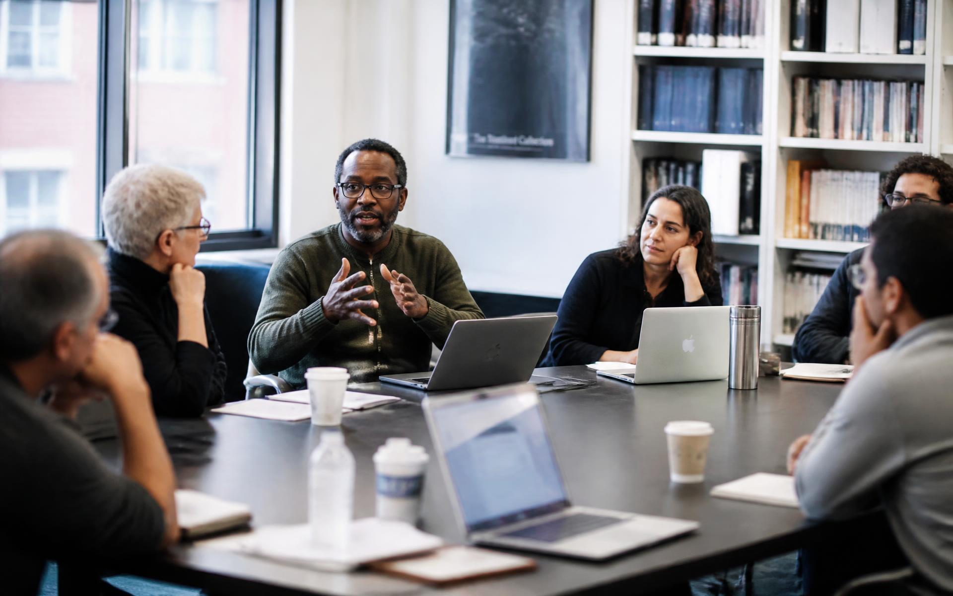 Educators and researchers in discussion around a seminar table